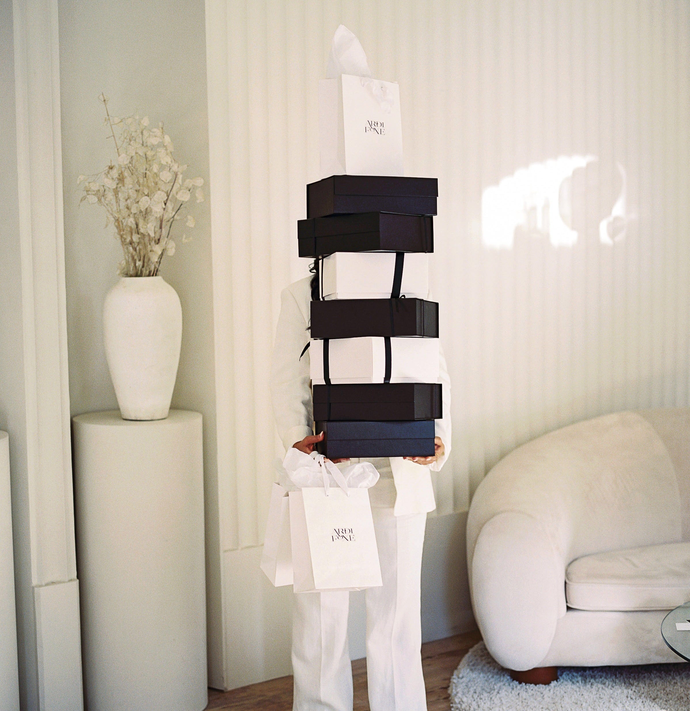 Ardi foxe founder standing with gift boxes photoshoot